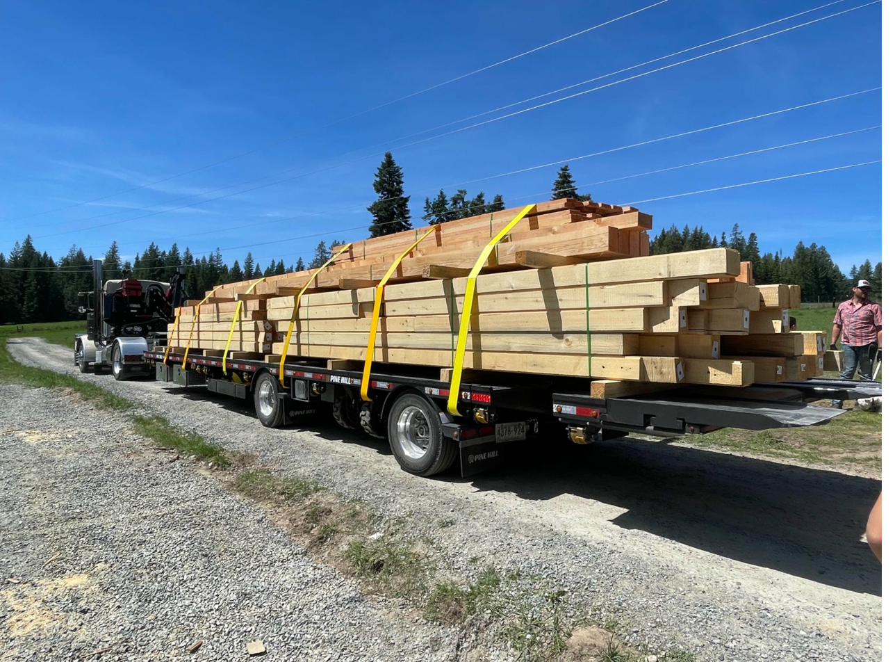 Cabin kit lumber being delivered by flatbed